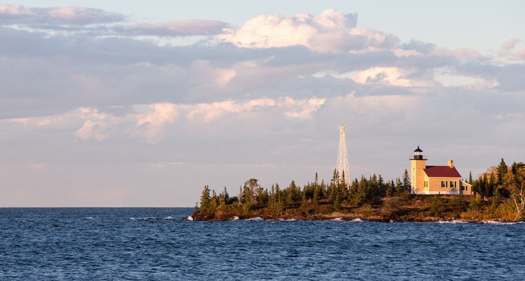 A lake and a view of of a lighthouse at dusk on Keweenaw Peninsula in Upper Michigan