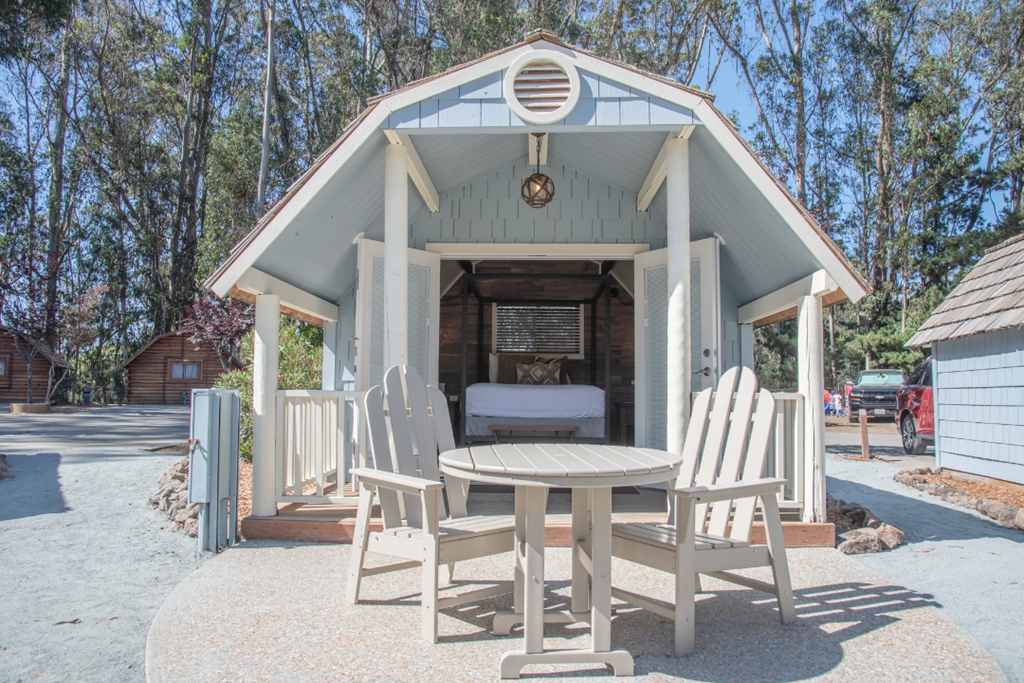 Photo of a light blue glamping cottage with the doors open at Santa Cruz Monterey Bay KOA Holiday California